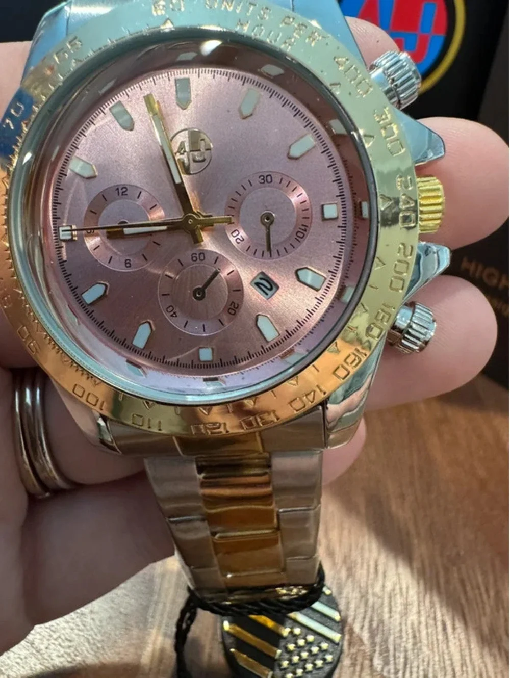 AJ stainless steel watch, pink face, gold & silver toned band